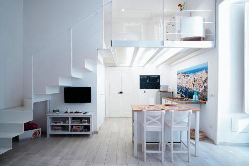 een woonkamer met een trap en een tafel en stoelen bij Mare Napoli in Napels