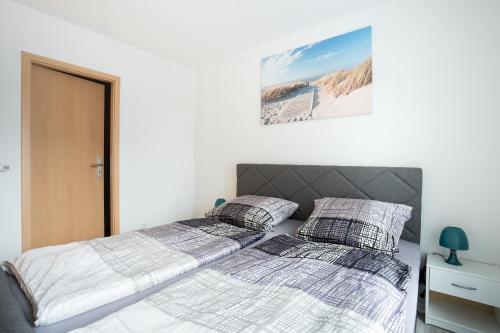 2 camas en un dormitorio con paredes blancas en CaSa Apartment Svea - 2x Parken-Amazon Prime-Terasse-Garten-Vollausstattung, en Erfurt