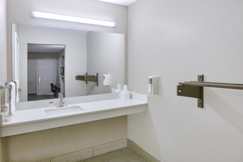 a bathroom with a sink and a mirror at Super 8 by Wyndham Moss Point in Moss Point