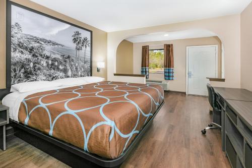 a bedroom with a large bed and a bathroom at Super 8 by Wyndham Moss Point in Moss Point