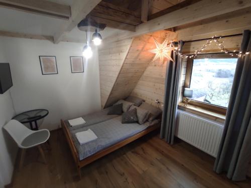 MaruszynaにあるAgroturystyka w Maruszynieのベッドと窓が備わる小さな客室です。