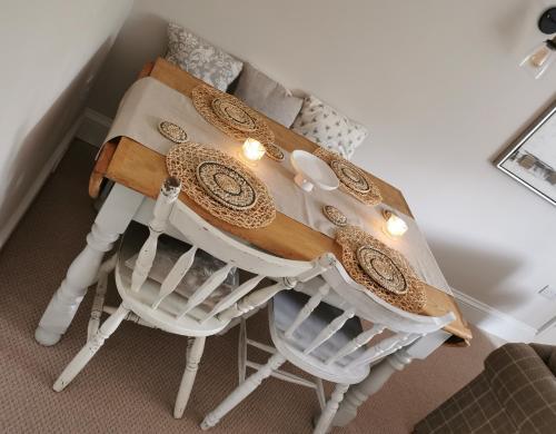 a table with cushioned chairs and a table with at Beehive Cottage in Beccles