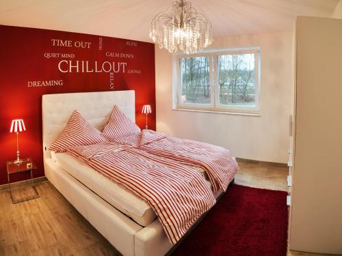 a bedroom with a bed with a red wall at Charming Apartments am See in Bad Saarow