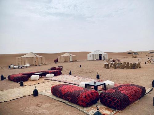 Un desierto con domos y tiendas en la arena en Couleur du désert, en Mhamid