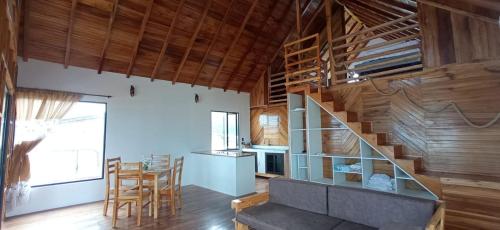 a living room with a staircase in a room with wooden walls at Chalet del Pacífico in Jama