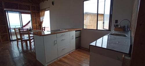a kitchen with white cabinets and a counter top at Chalet del Pacífico in Jama