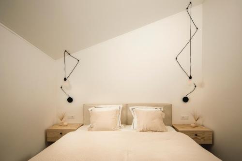1 dormitorio con 1 cama blanca y 2 almohadas en Bird's eye view, Hillside, en Dolný Kubín