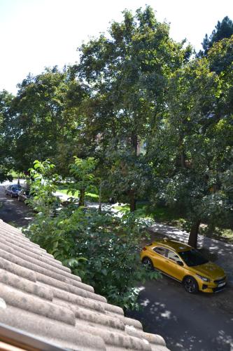 a yellow car parked on a street with trees at Pension U akátu in Prague