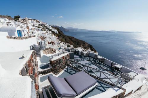a balcony with a view of the ocean on a cliff at Aspa Caves in Oia