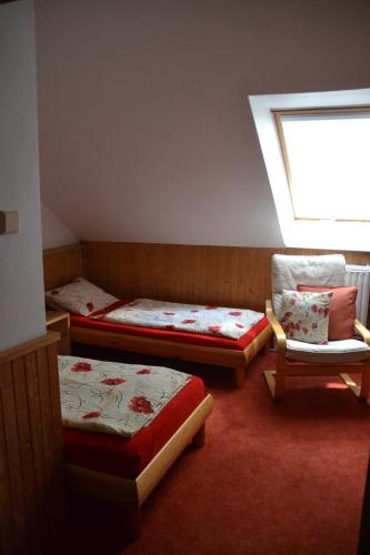 a room with three beds and a window and a chair at Pension U akátu in Prague