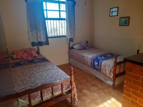 sypialnia z 2 łóżkami i oknem w obiekcie Cantinho da Lagoa w mieście Araruama