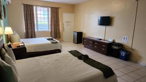 a hotel room with two beds and a television at Combate Beach Resort in Cabo Rojo