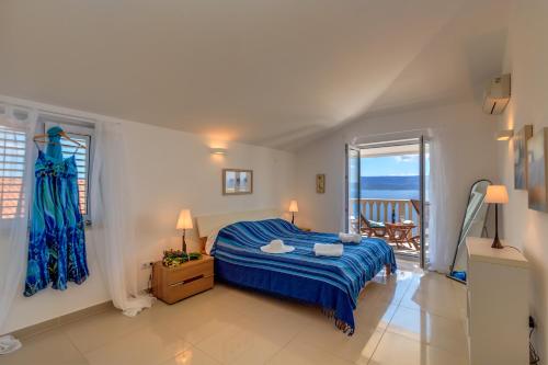 a bedroom with a blue bed and a balcony at Villa Katarina in Stanići