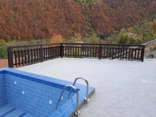 une grande terrasse avec une balustrade en bois. dans l'établissement Vila Kula, à Crni Vrh