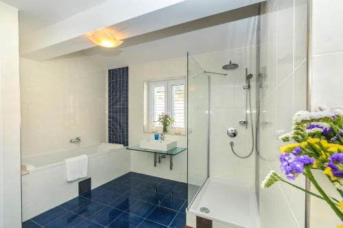 a bathroom with a shower and a tub and a sink at Villa Katarina in Stanići