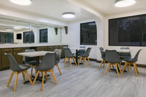 a waiting room with tables and chairs and windows at Super 8 by Wyndham Moss Point in Moss Point