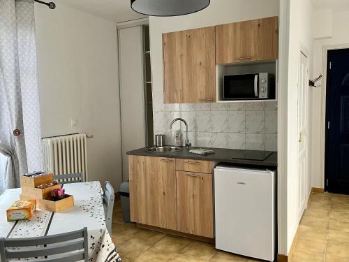 a small kitchen with a table and a microwave at Studio indépendant dans maison individuelle in Nancy