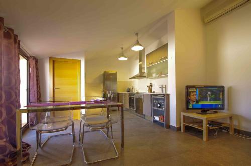 a kitchen with a table and chairs and a television at Matarolux 1 in Mataró