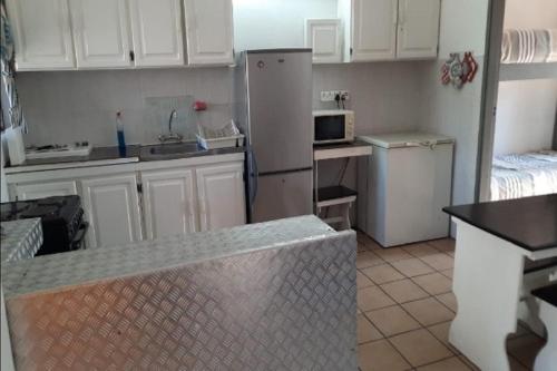 eine Küche mit weißen Schränken und einem weißen Kühlschrank in der Unterkunft St Lucia Villa Mia 11 in St Lucia