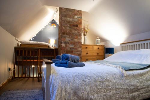Un dormitorio con una cama con toallas azules. en The Bolthole barn with wood-fired hot tub en Glentworth