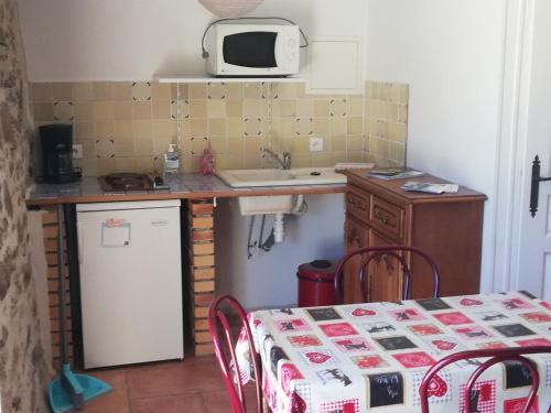 a small kitchen with a table and a microwave at AUBERGE LA BOUCHOLIERE in Parthenay