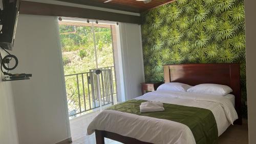 a bedroom with a bed with a green wall at ROCCA VENTO in Bajo Boquete