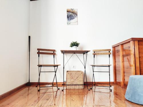 a room with two bar stools and a table at Casa d'Avó in Carrapateira