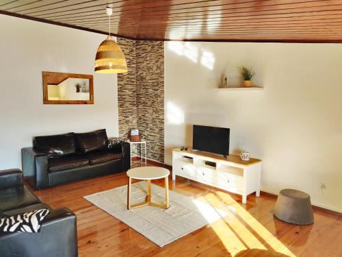een woonkamer met een bank en een tv bij Casa d'Avó in Carrapateira