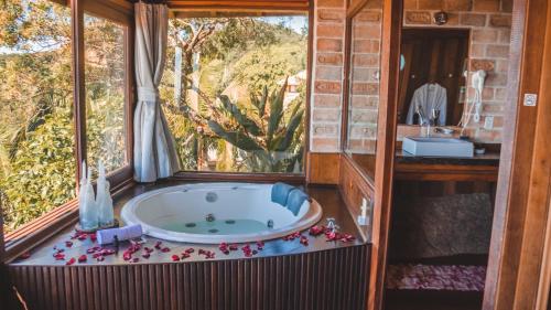 eine Badewanne in einem Raum mit Fenster in der Unterkunft Pousada Caminho do Rei in Praia do Rosa