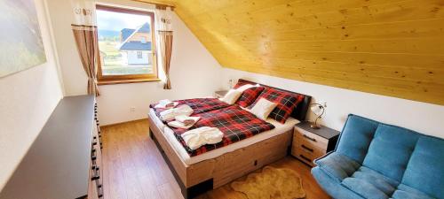 a small bedroom with a bed and a blue couch at chalupa Český štít Vysoké Tatry in Stará Lesná