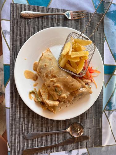 a plate of food with a fish and french fries at Nungwi Beach Front in Nungwi