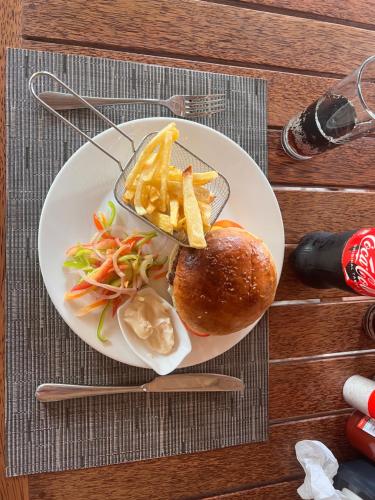 a plate of food with a sandwich and french fries at Nungwi Beach Front in Nungwi