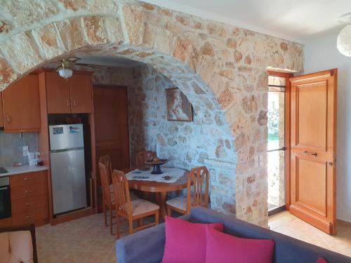 a living room with a table and a kitchen at Nireas : Stone Villa in Zakynthos