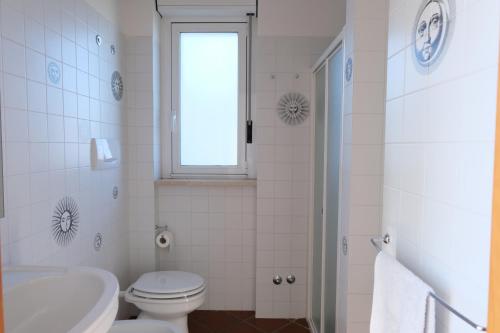 a bathroom with a toilet and a sink and a window at Terrazza Dolce Vista in Monopoli