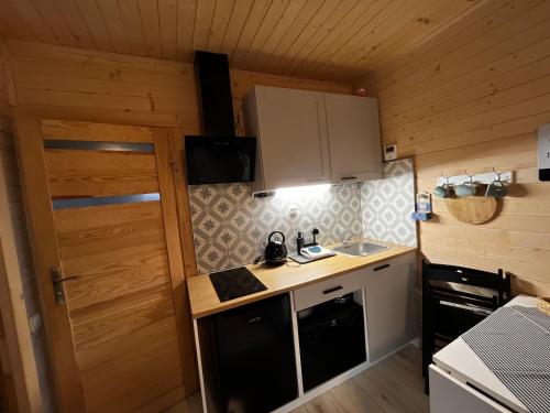 a small kitchen with a sink and a stove at Lazy Deer - Camp in Staniszów