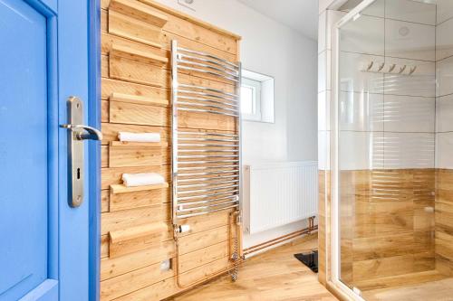 uma casa de banho com um chuveiro e uma parede de madeira em Chalupa Česká Kanada em Dobrohoř
