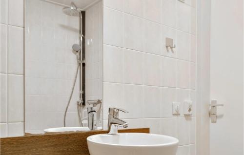 y baño blanco con lavabo y ducha. en Awesome Home In Vlagtwedde With Kitchen, en Vlagtwedde