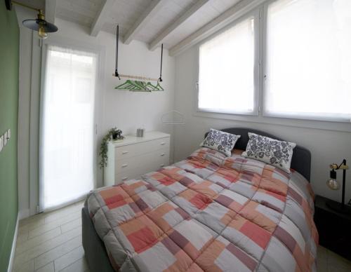 a bedroom with a large bed and two windows at La brezza del lago in Marone