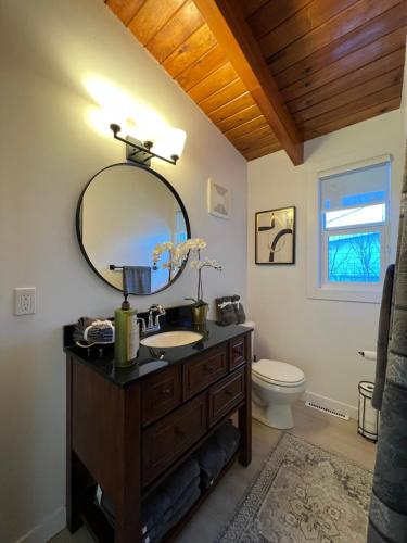 La salle de bains est pourvue d'un lavabo et d'un miroir. dans l'établissement ! 5 Bed Beautiful Home with Fenced Yard & Hammock! WEM - Foosball Table - WiFi - Fireplace - Long Stay, à Edmonton