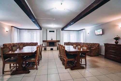 a dining room with tables and chairs and a couch at Complex Turistic Bucovina in Suceviţa