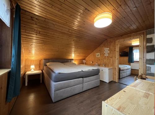 una camera da letto con letto in una camera in legno di Horská Chata U Kameníčka a Jáchymov