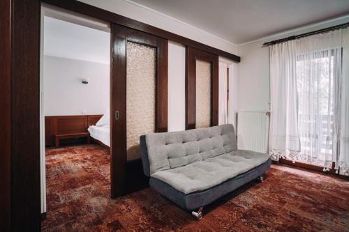 a living room with a couch and a bed at Complex Turistic Bucovina in Suceviţa
