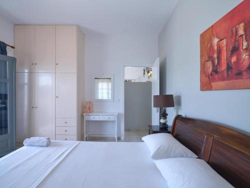 a white bedroom with two beds and a desk at VILLA ALEXANDROS in Naousa