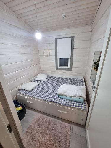 a small bedroom with a bed in a tiny house at Holiday home Korpraali by Päijänne-lake in Vaajakoski