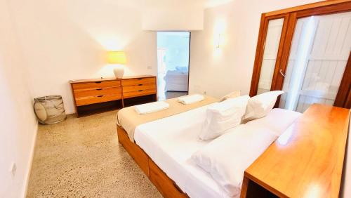 1 dormitorio con 1 cama blanca grande y vestidor en Villa Boutique ibiza, en Santa Eulària des Riu
