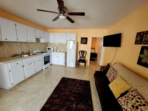 een keuken en een woonkamer met een bank en een plafondventilator bij Kaylavill in Nassau