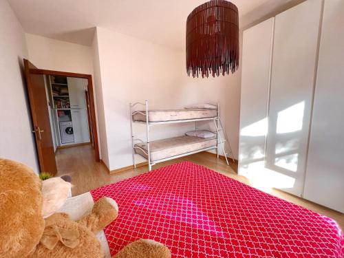 um quarto com um ursinho de peluche e um tapete vermelho em Lovely apartment a due passi dal mare em Rimini