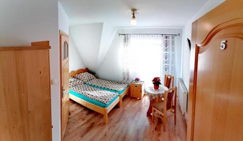 a small bedroom with a bed and a window at Pokoje u Janci i Stasia in Poronin