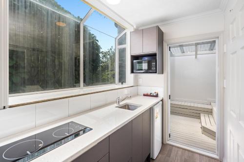 a kitchen with a sink and a large window at Ashleigh Court Motel in Rotorua