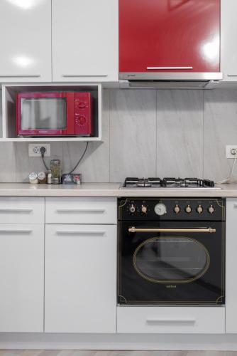 a kitchen with a black oven and a microwave at Royal Accommodation in Bucharest